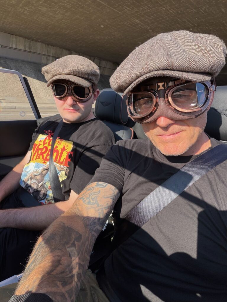 Lil Noah and Noah in driving caps and goggles on a Morgan road trip
