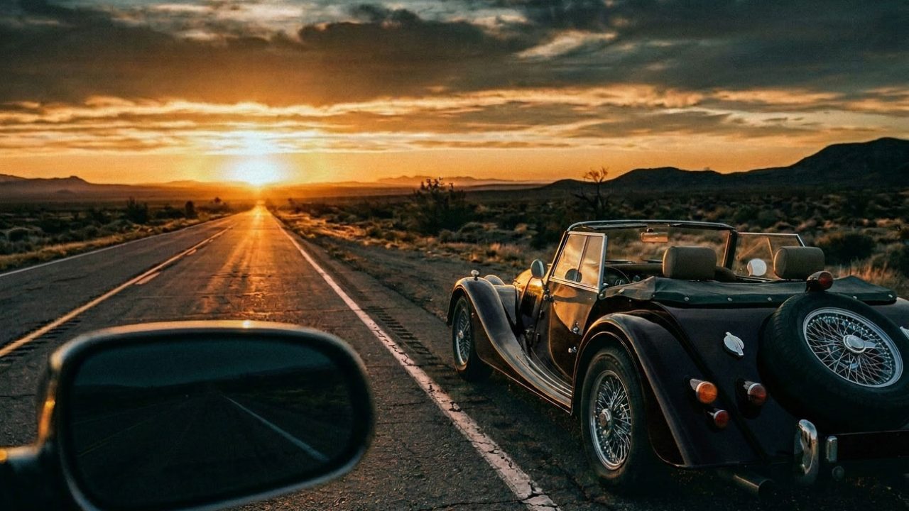 letting go of the past, vintage convertible driving forward on an open road at sunset