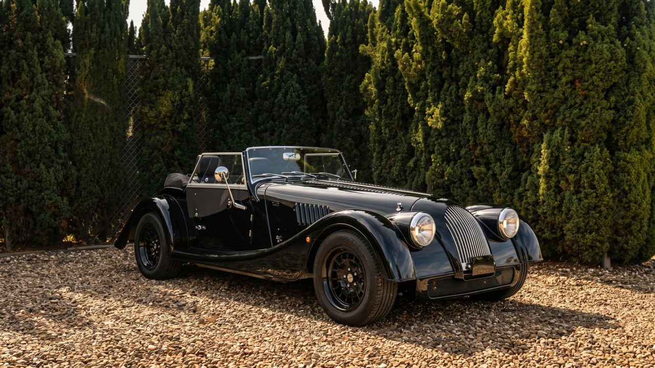 Momentum Markers September 2026, Audrey the black custom Morgan Plus Four parked on gravel in the sun